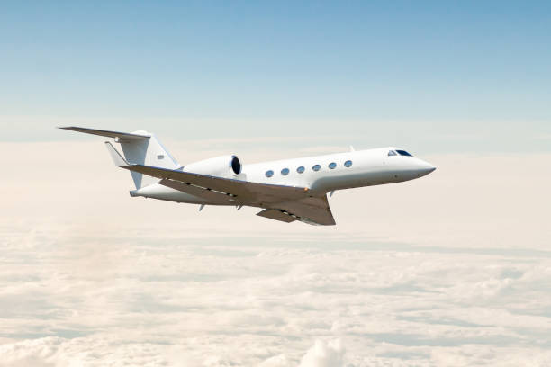 white luxury business jet flying in the air above the clouds